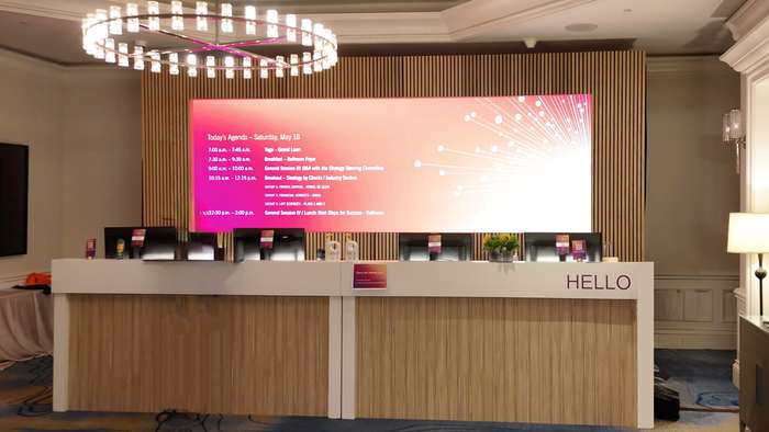 Event registration desk with an LED agenda screen